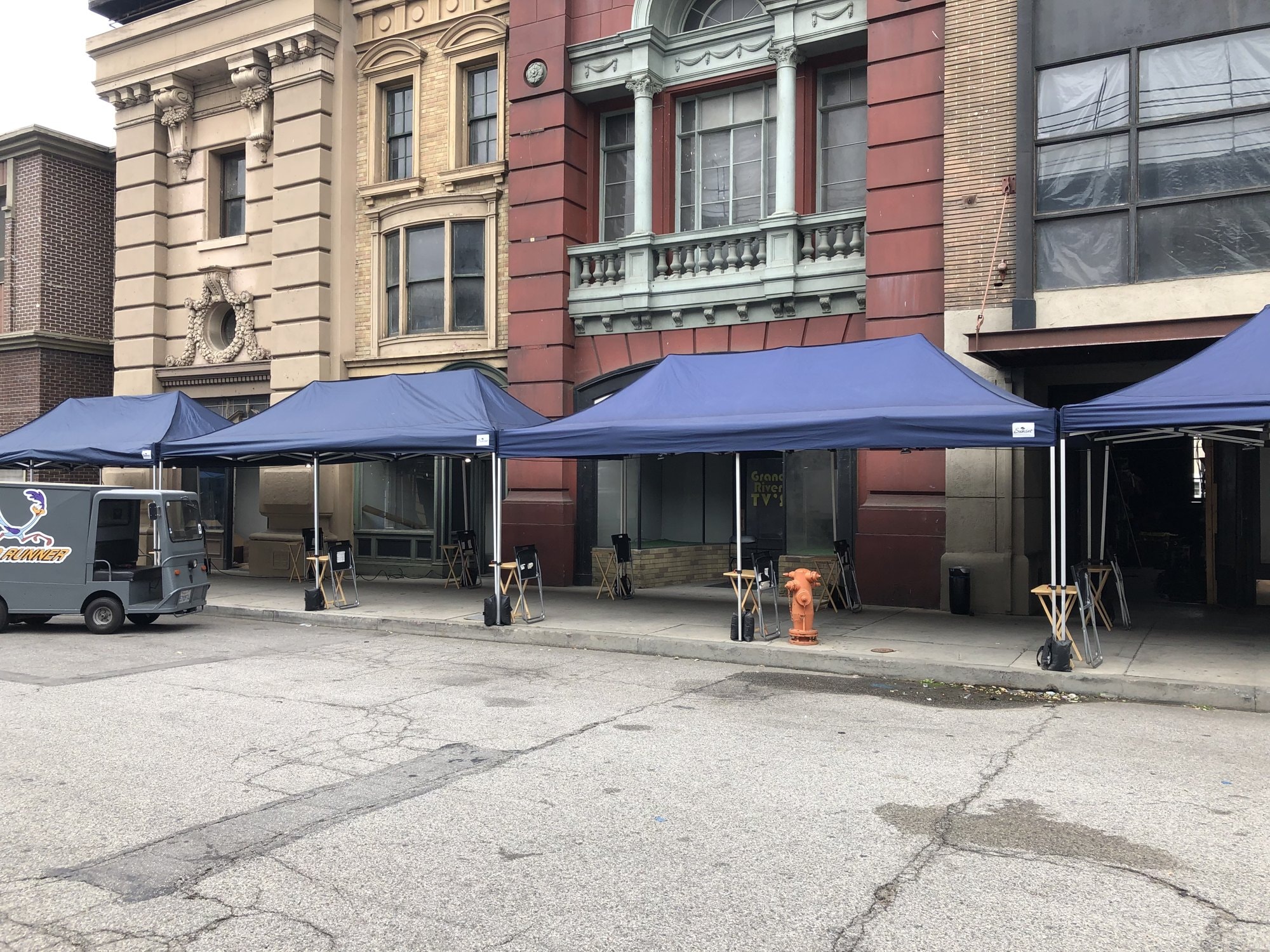 Navy Sunset tents lining a studio backlot street with tables and chairs