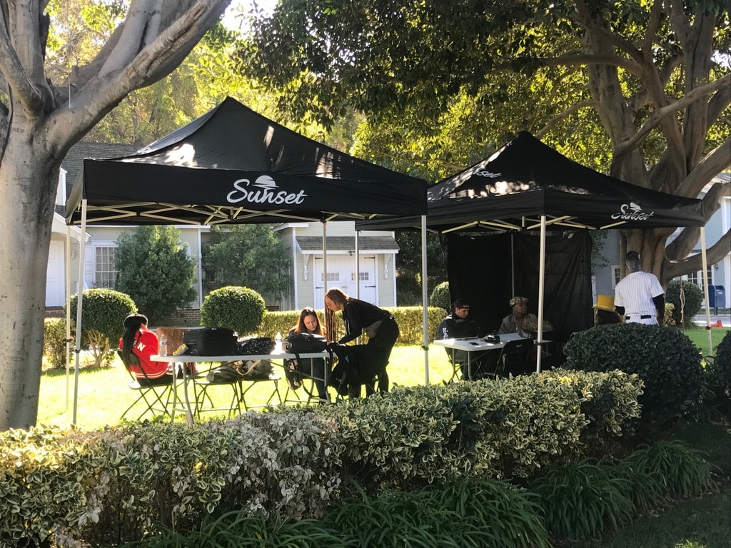 Black Sunset tents with crew working on a studio backlot street