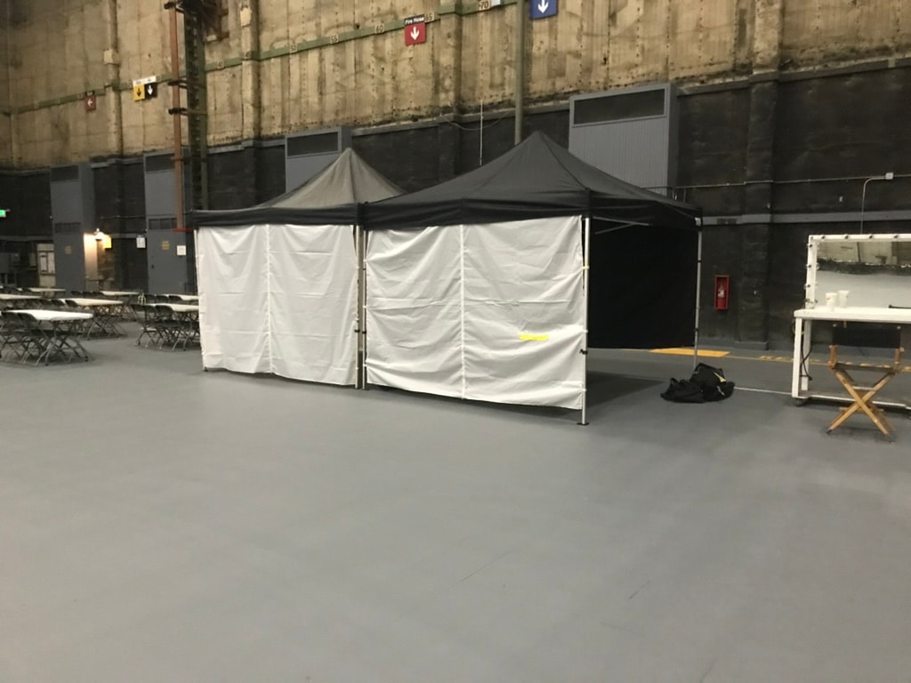 Black Sunset tents with white sidewalls used as changing rooms on a soundstage