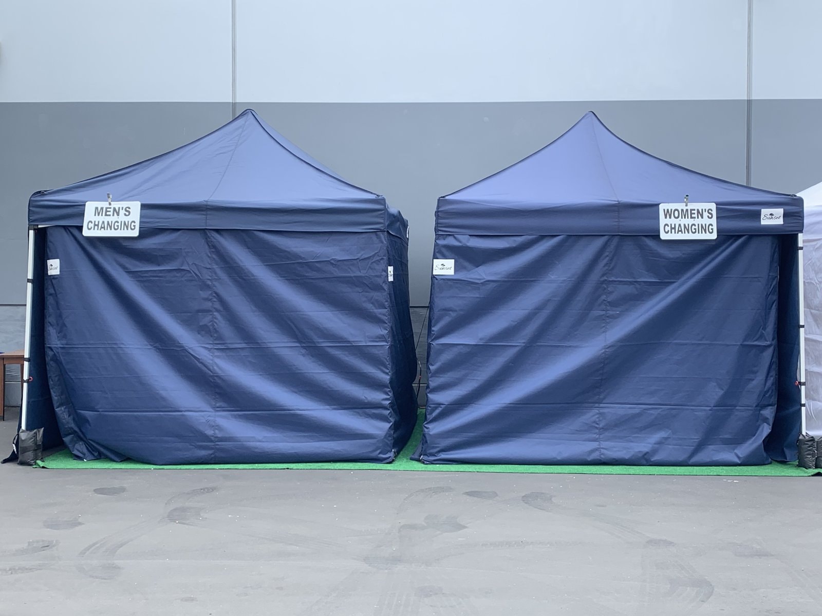 Sunset men's and women's navy changing tents side by side on a studio lot