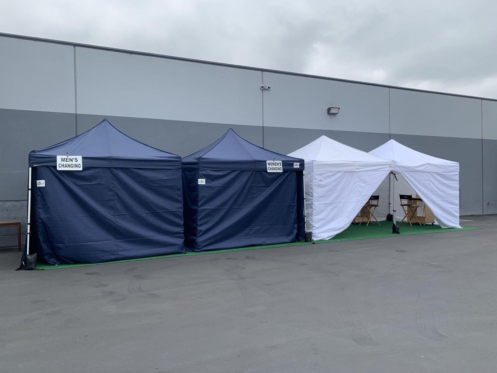 Sunset navy changing tents and white wardrobe tent lined up outside a warehouse