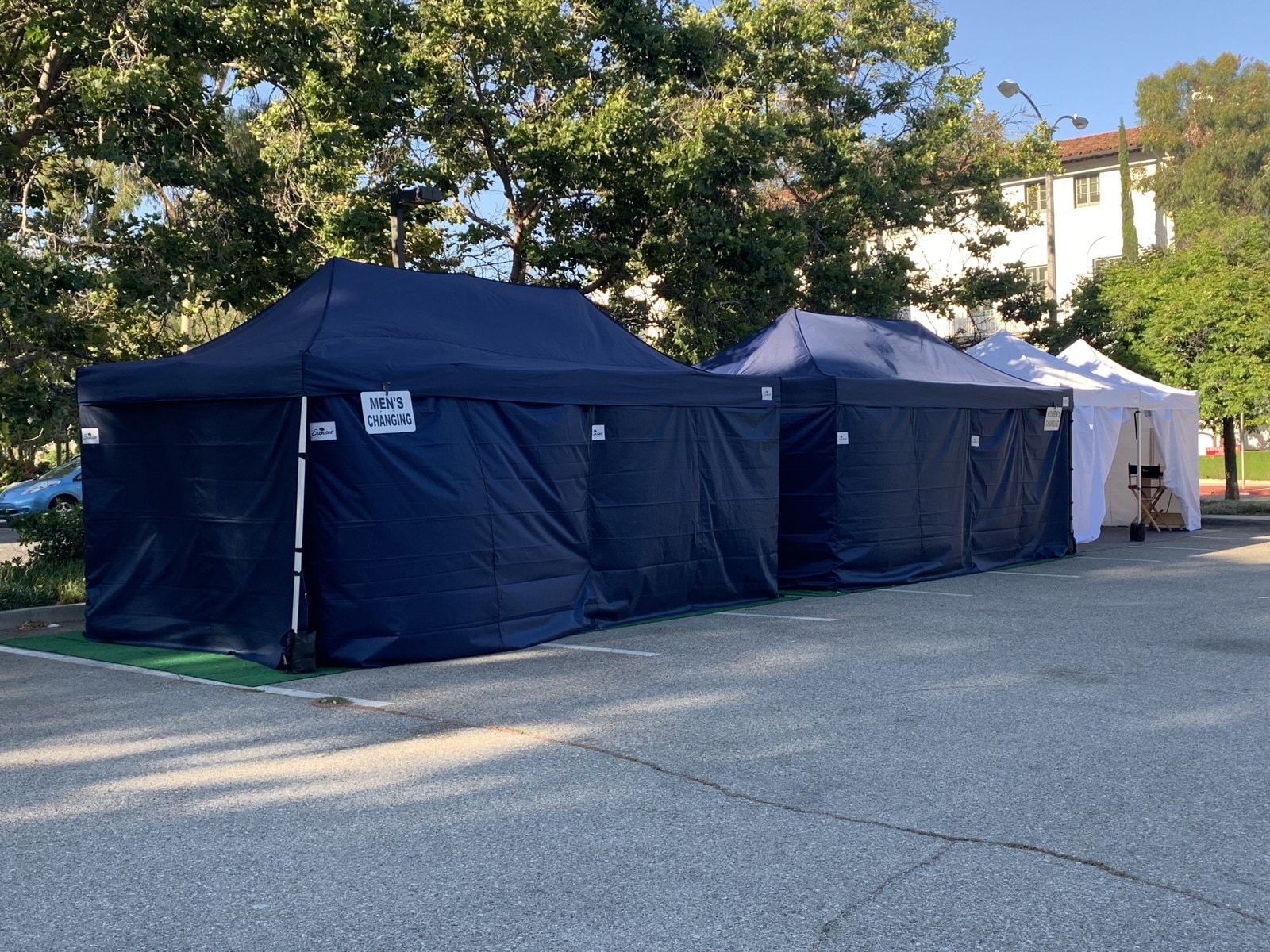 Sunset navy men's changing tent and white wardrobe tent in a parking lot