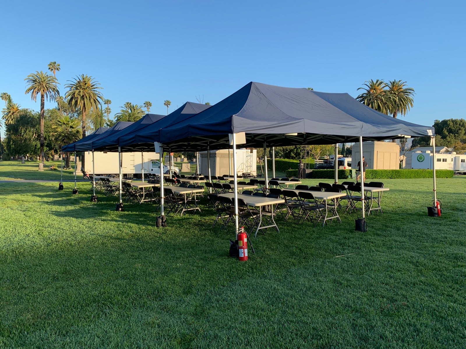Row of Sunset navy lunch tents lining a shaded campus walkway